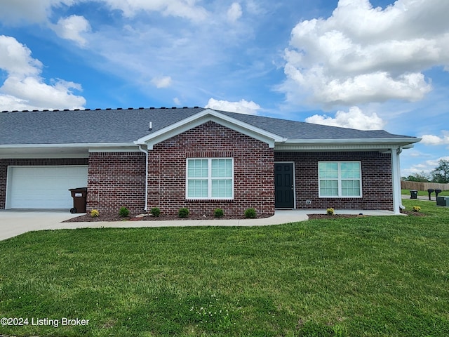 ranch-style home featuring a garage and a front lawn