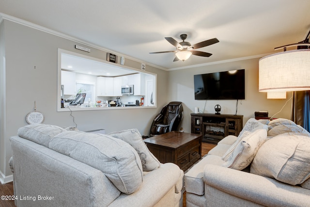 living room with ceiling fan, wood-type flooring, and ornamental molding