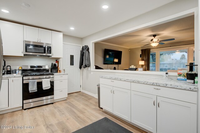 kitchen featuring white cabinetry, appliances with stainless steel finishes, ceiling fan, and light wood-type flooring