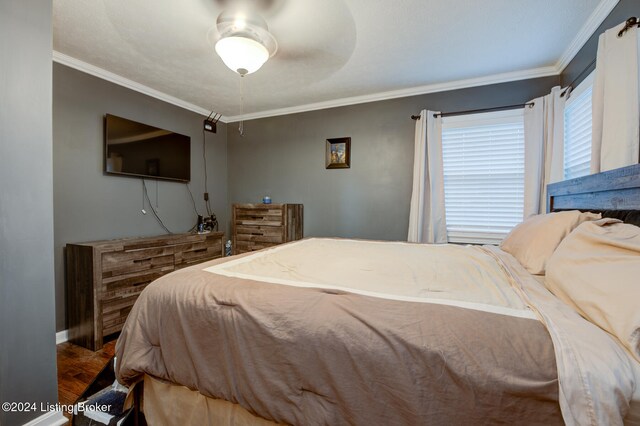 bedroom featuring ornamental molding, wood-type flooring, and ceiling fan