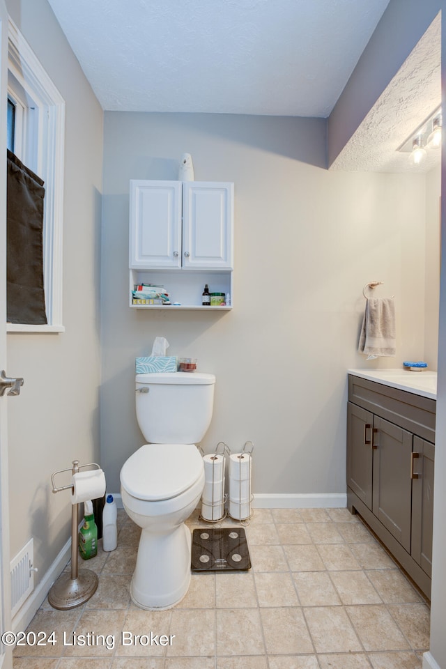 bathroom featuring toilet, vanity, and tile patterned flooring