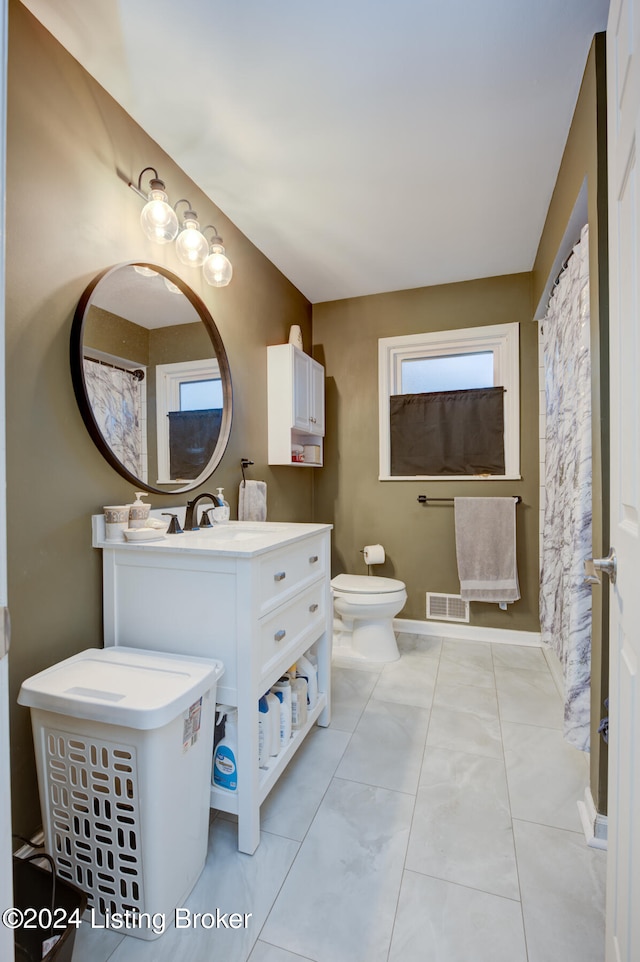 bathroom featuring vanity, tile patterned floors, and toilet