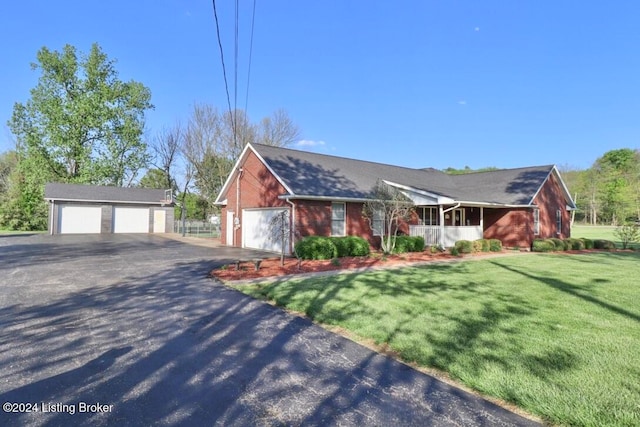 ranch-style house featuring an outbuilding, a garage, and a front lawn