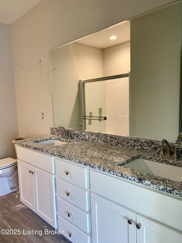 full bath featuring a sink, toilet, and double vanity