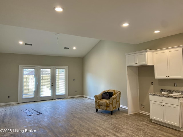 living area with recessed lighting, visible vents, and baseboards