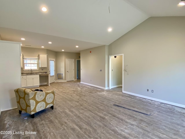 living area with light wood-style floors, recessed lighting, high vaulted ceiling, and baseboards