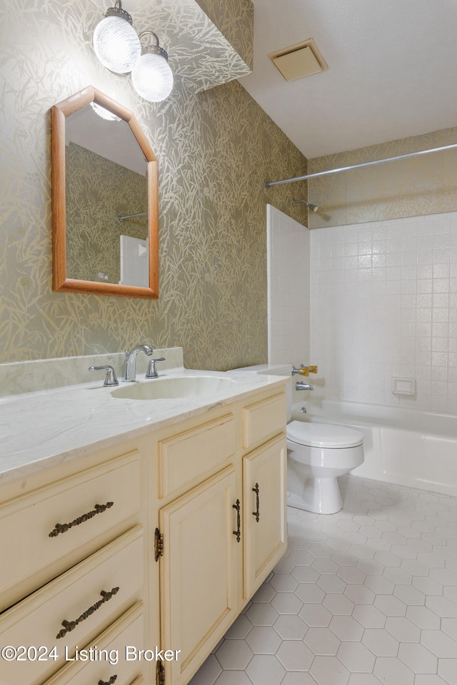 full bathroom featuring tile patterned flooring, vanity, tiled shower / bath combo, and toilet