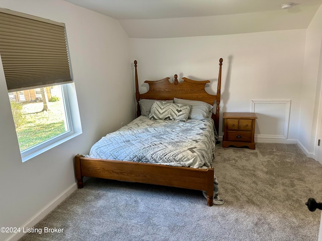 carpeted bedroom with lofted ceiling