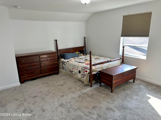 bedroom featuring light colored carpet and vaulted ceiling