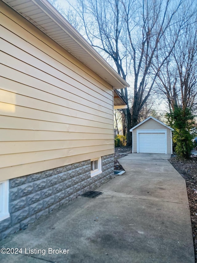 view of side of property with a garage and an outbuilding