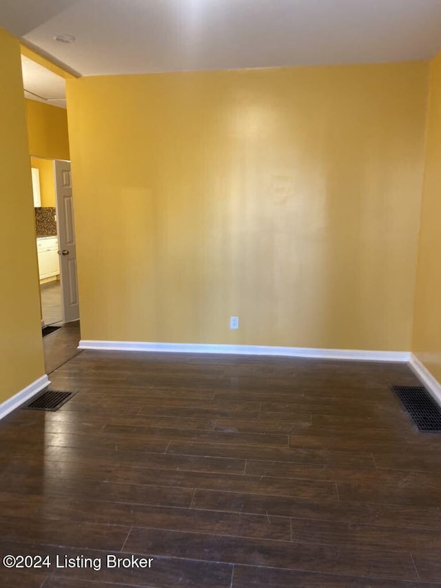 spare room featuring dark wood-type flooring