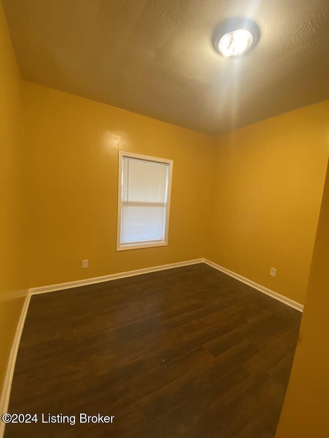 spare room with dark hardwood / wood-style flooring