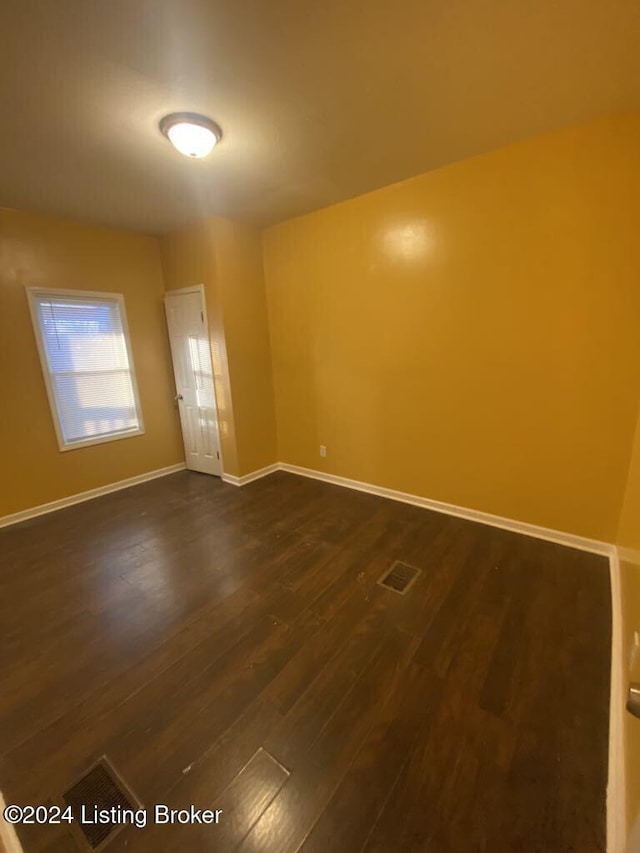 spare room with dark wood-type flooring