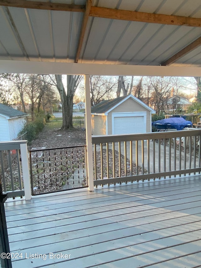 deck with a garage and a storage shed