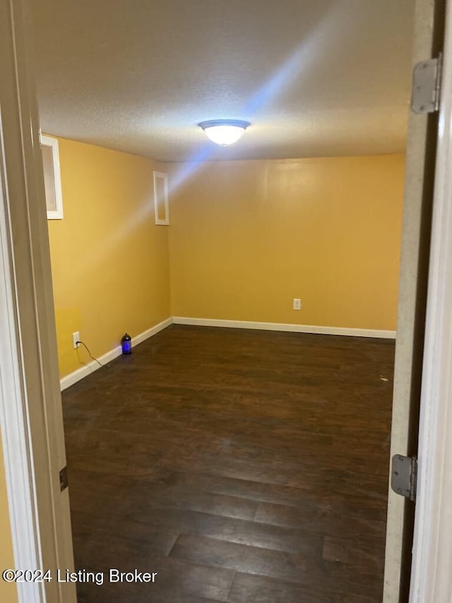 basement with dark hardwood / wood-style floors