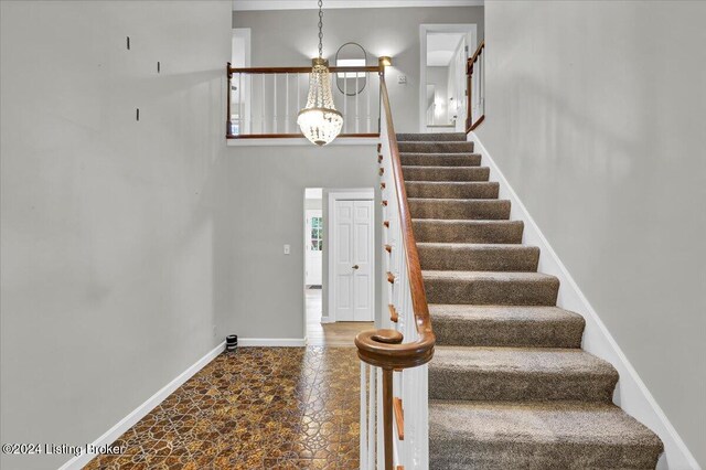 staircase featuring a notable chandelier