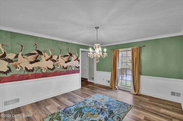 dining room featuring hardwood / wood-style floors, an inviting chandelier, and ornamental molding