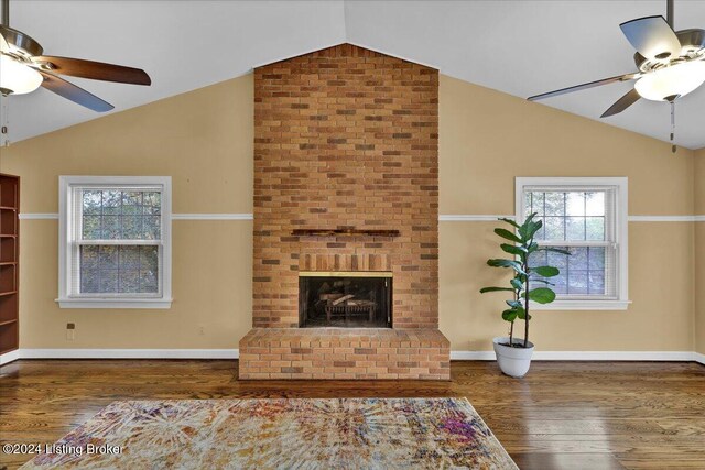 living room with lofted ceiling, a healthy amount of sunlight, ceiling fan, and dark wood-type flooring