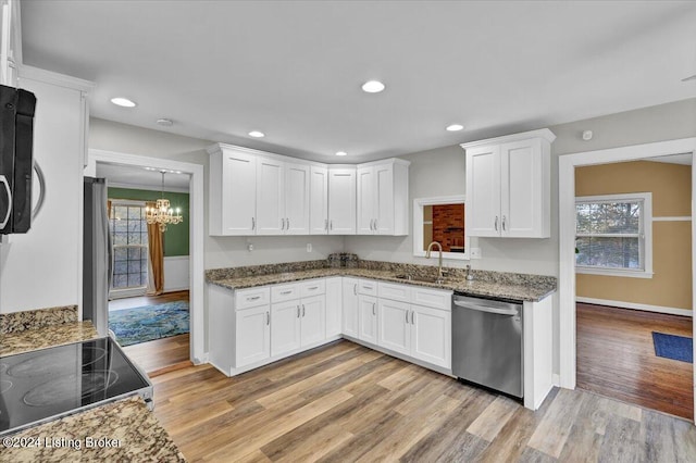 kitchen featuring white cabinets, black appliances, and light hardwood / wood-style flooring