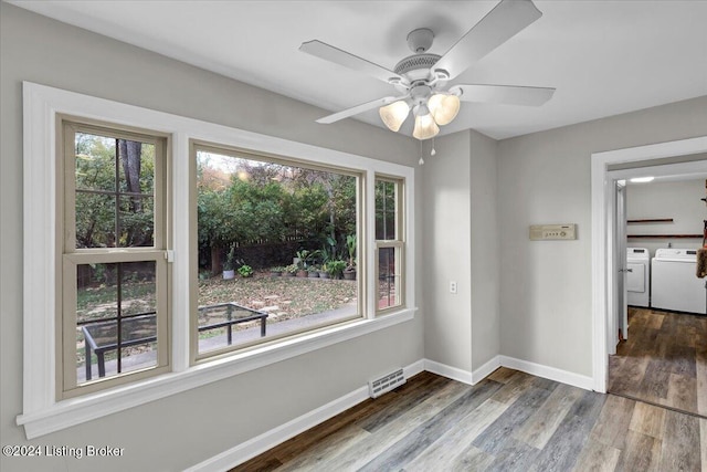 spare room with wood-type flooring, ceiling fan, and washing machine and clothes dryer