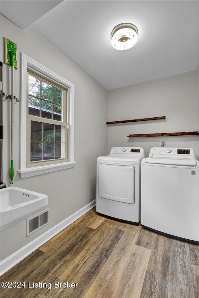 washroom featuring washer and clothes dryer and light wood-type flooring