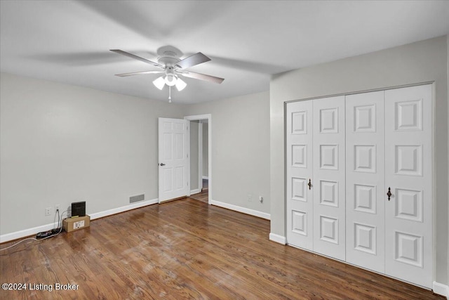 unfurnished bedroom featuring hardwood / wood-style flooring, ceiling fan, and a closet