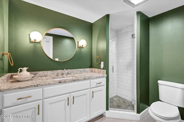 bathroom featuring vanity, toilet, and a shower with door