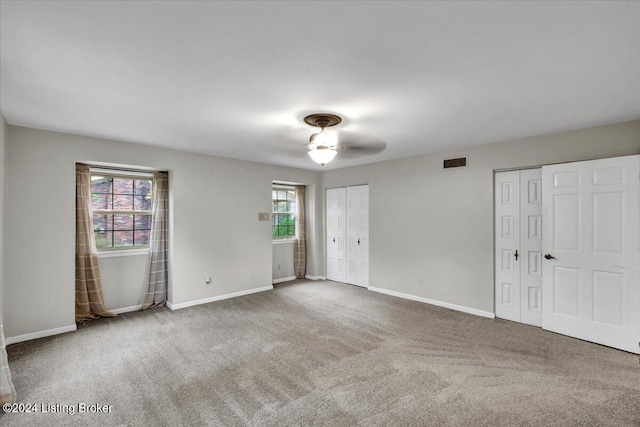 carpeted spare room with ceiling fan