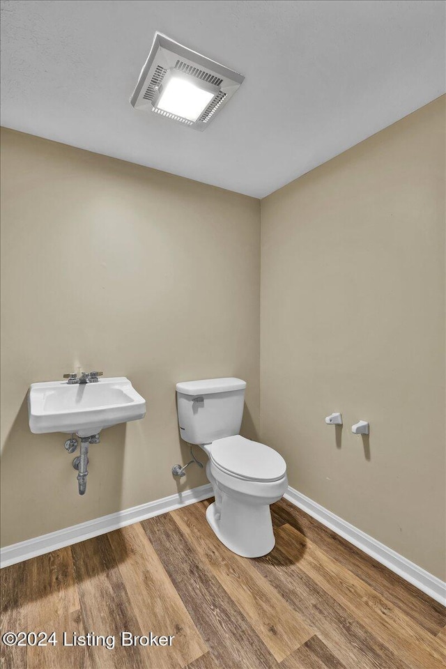 bathroom with hardwood / wood-style floors, toilet, and sink