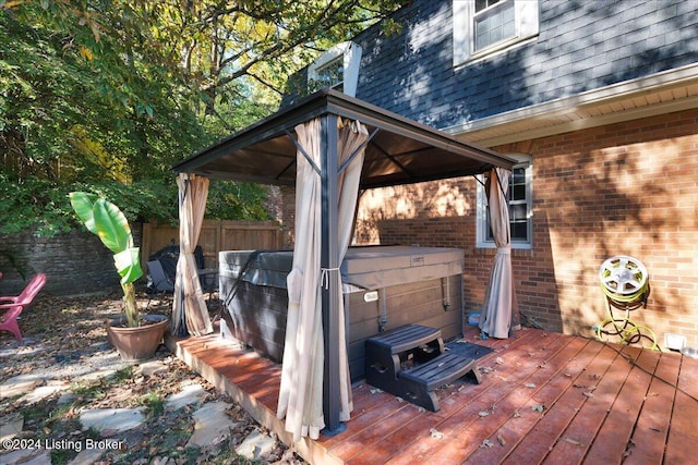 deck with a hot tub and a gazebo