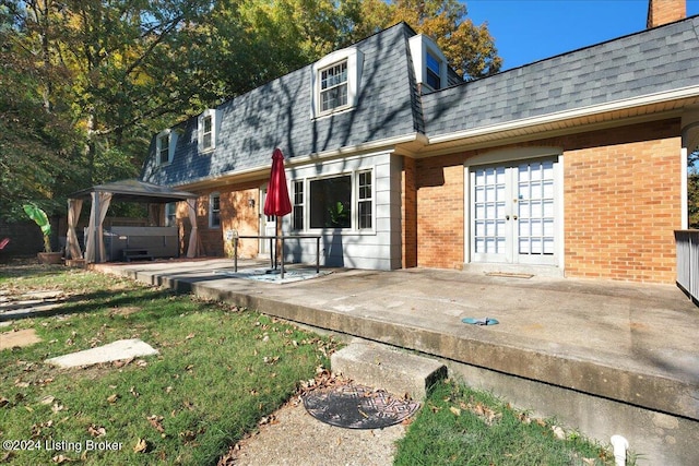 back of property featuring a jacuzzi, a gazebo, french doors, and a patio area