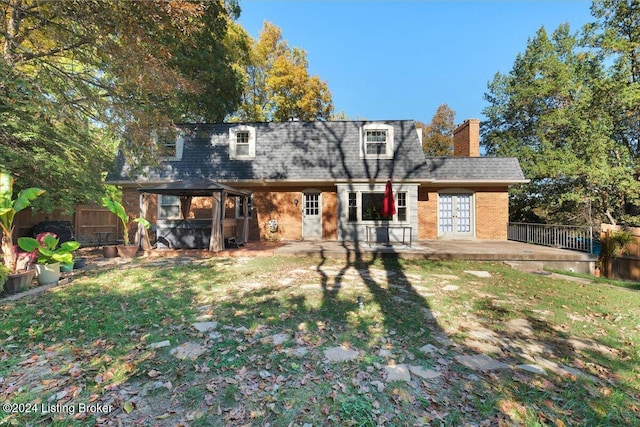 rear view of property featuring a lawn and a patio area