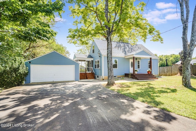 view of front of property featuring a garage, an outbuilding, and a front lawn