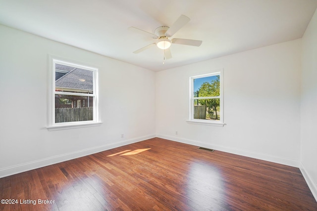 empty room with dark wood-type flooring and ceiling fan