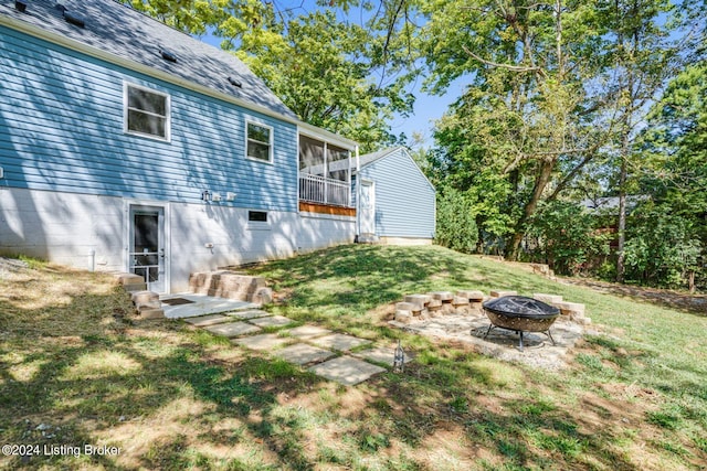 view of yard with a sunroom and a fire pit