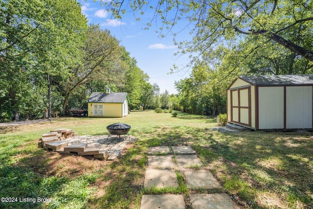 view of yard featuring a storage shed and an outdoor fire pit