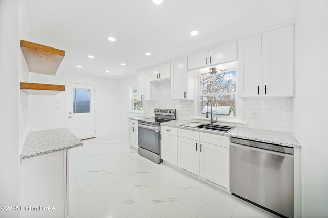 kitchen featuring stainless steel appliances, white cabinetry, sink, and tasteful backsplash