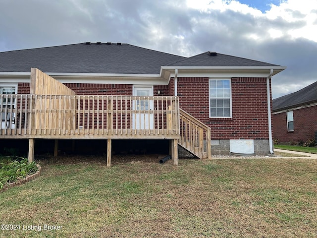 rear view of property with a yard and a deck