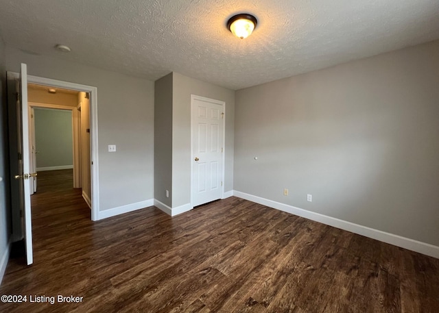 unfurnished bedroom featuring dark wood-type flooring, a closet, and a textured ceiling