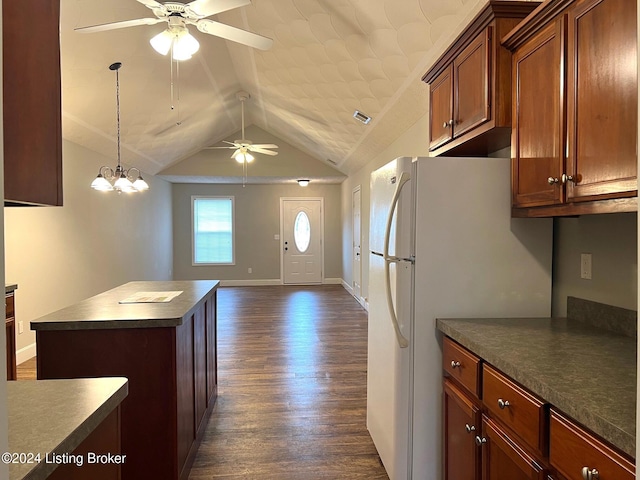 kitchen featuring ceiling fan with notable chandelier, lofted ceiling, a kitchen island, white fridge, and dark hardwood / wood-style flooring