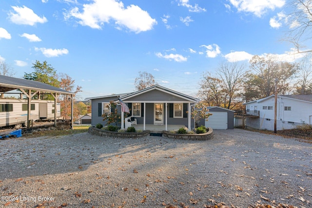 view of front of home featuring a garage, an outdoor structure, and a porch