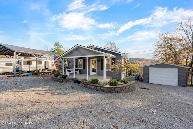 22 Harmony Ln, Clarkson, KY 42726 - view of front of property featuring an outdoor structure, a detached garage, gravel driveway, and covered porch