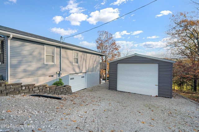 exterior space featuring a garage and an outbuilding