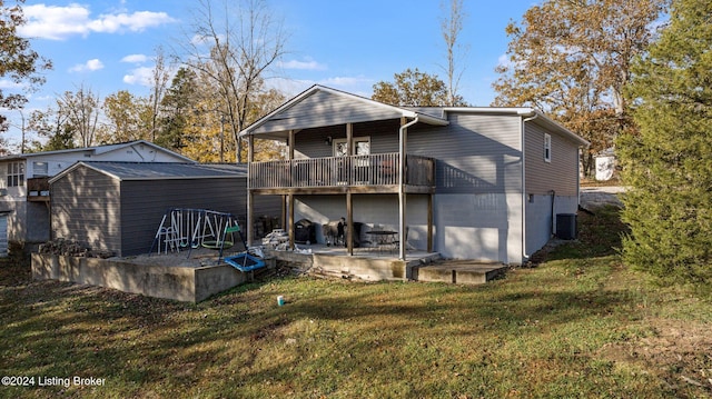 rear view of house featuring central AC, a wooden deck, a lawn, and a patio