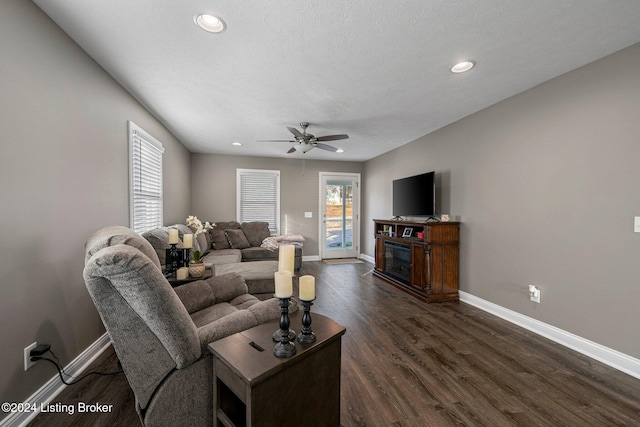 living room featuring ceiling fan, dark hardwood / wood-style floors, and a textured ceiling