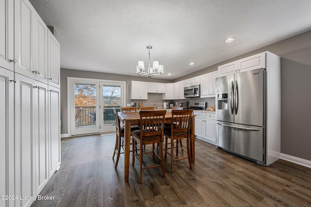 dining area with dark wood-type flooring, a chandelier, and a textured ceiling