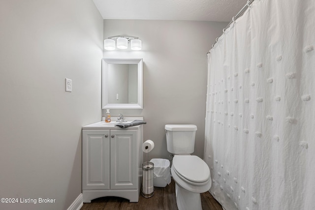 bathroom with toilet, vanity, a textured ceiling, and hardwood / wood-style flooring