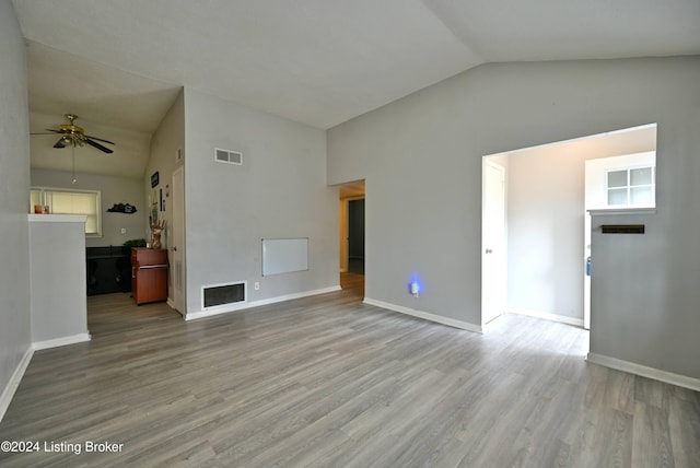 unfurnished living room featuring ceiling fan, light wood-type flooring, and vaulted ceiling