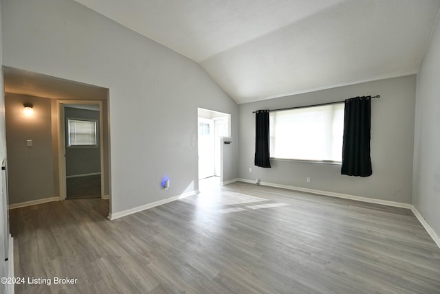 spare room with lofted ceiling and light hardwood / wood-style flooring