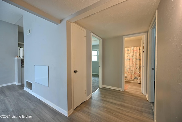 hallway featuring a textured ceiling and dark hardwood / wood-style floors